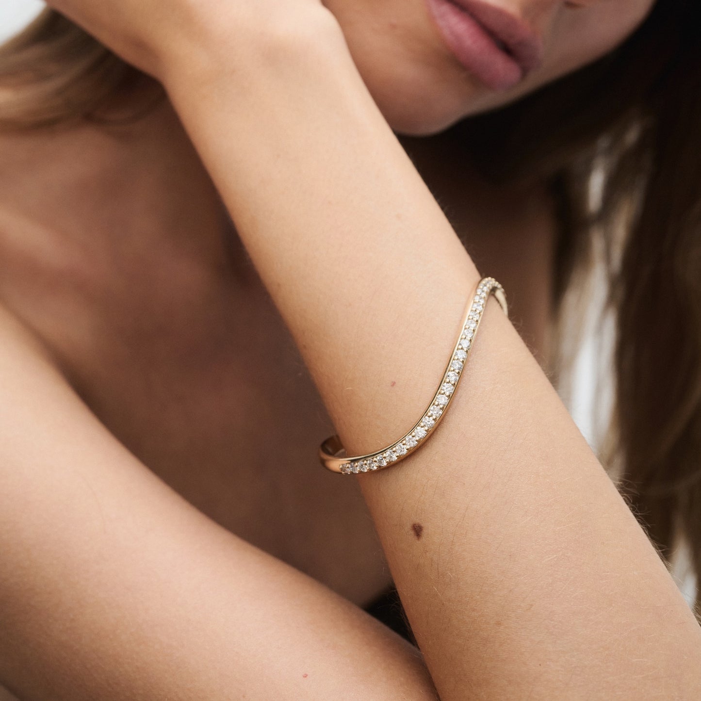 Woman wearing an elegant diamond bracelet on her arm; stylish, luxury jewellery piece.