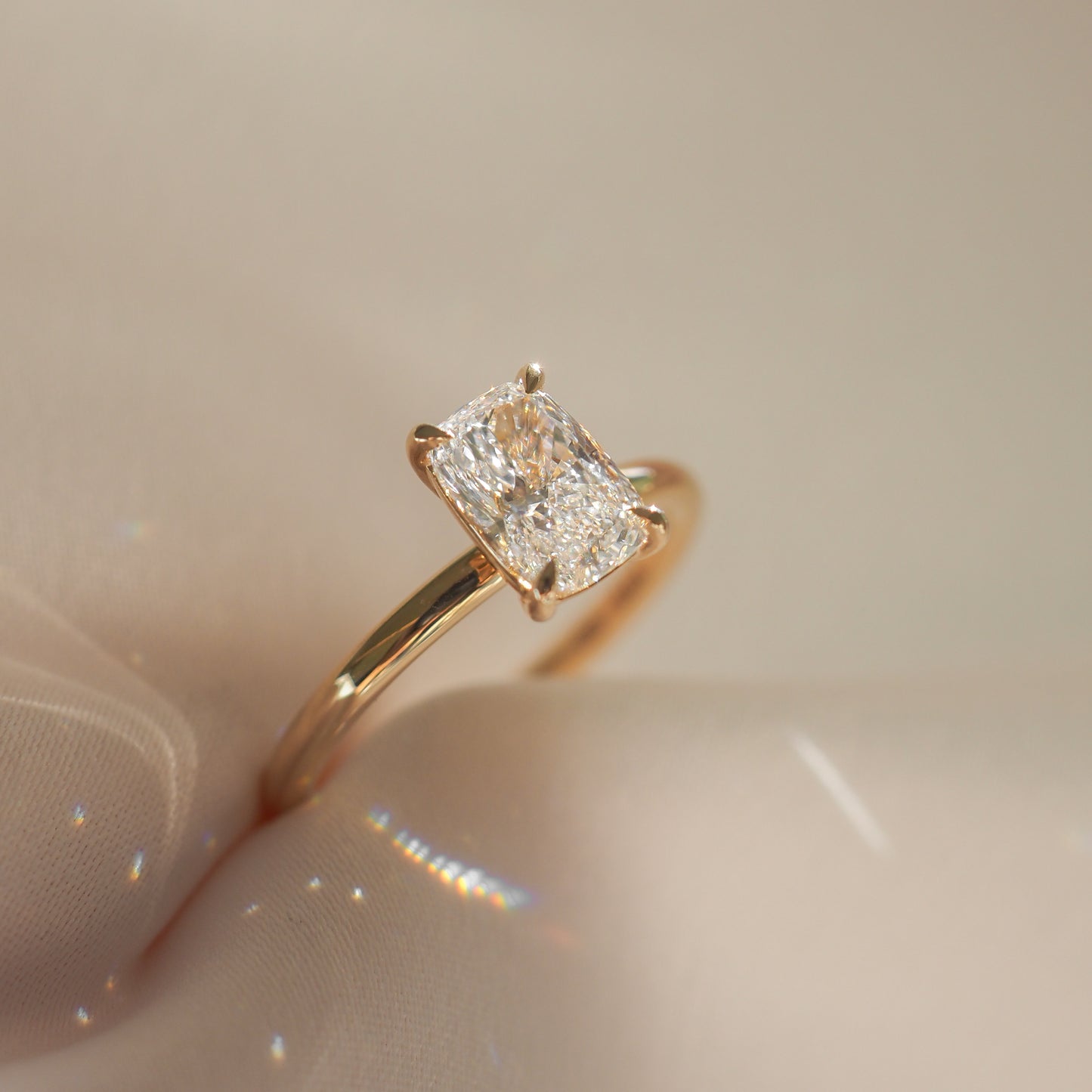 Gold ring with a large diamond on a beige background