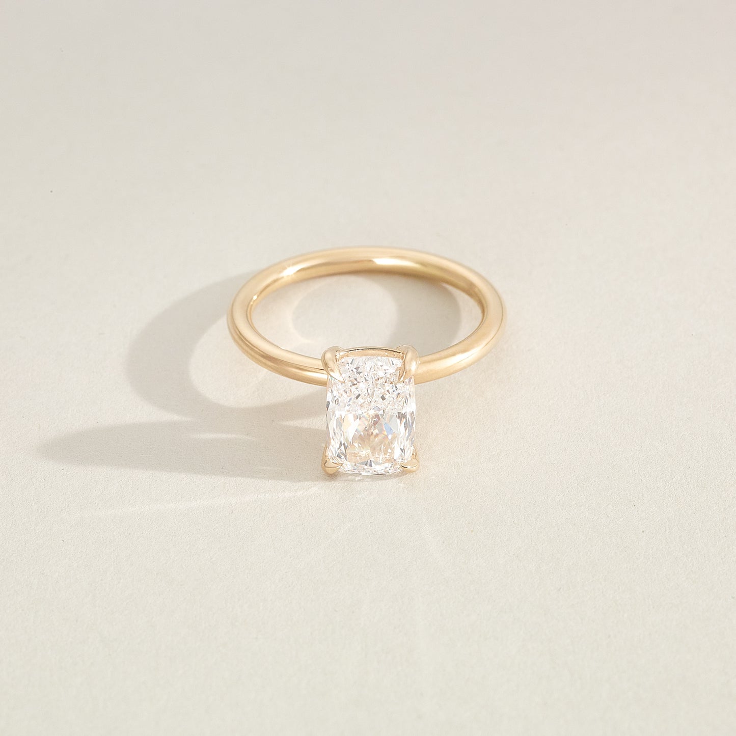 Gold ring with a diamond on a light beige background