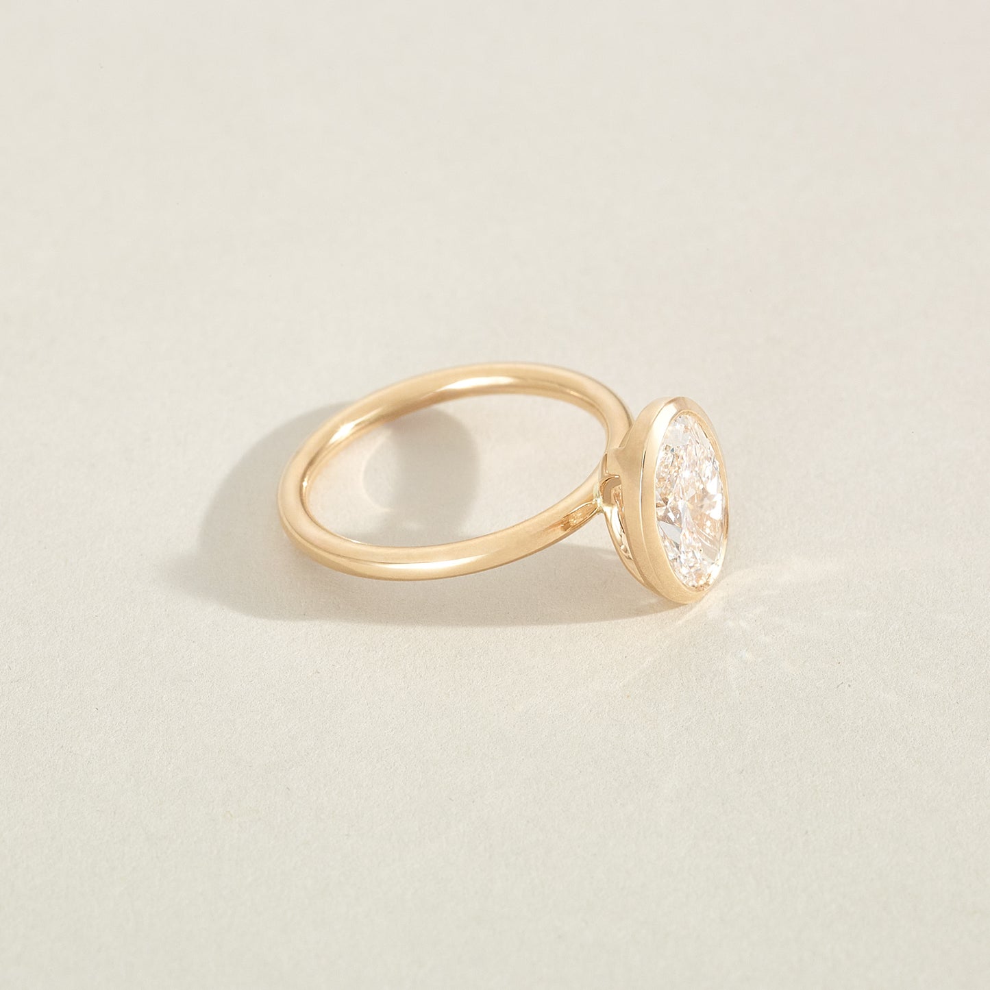 Gold ring with a textured gemstone on a light beige background