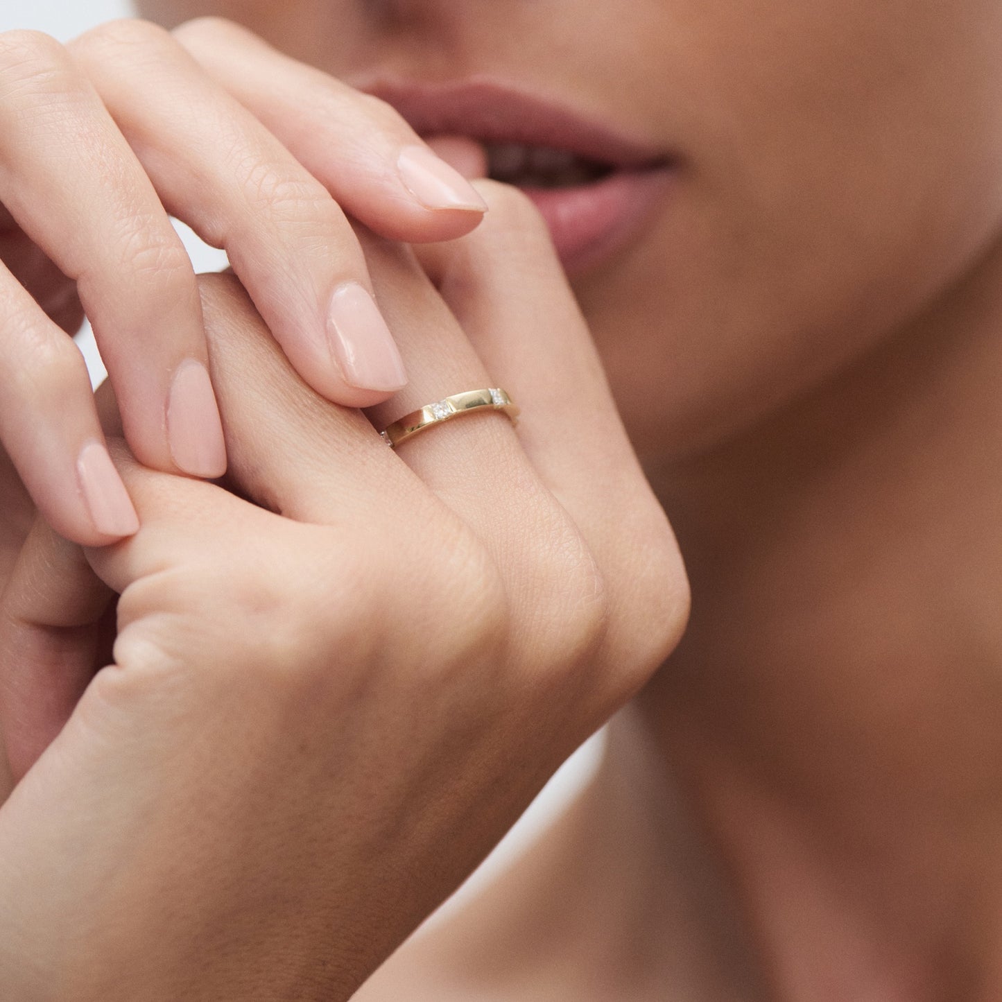 Elegant woman wearing a minimalist gold ring on her finger, showcasing luxury jewellery with a focus on refined details and subtle elegance.