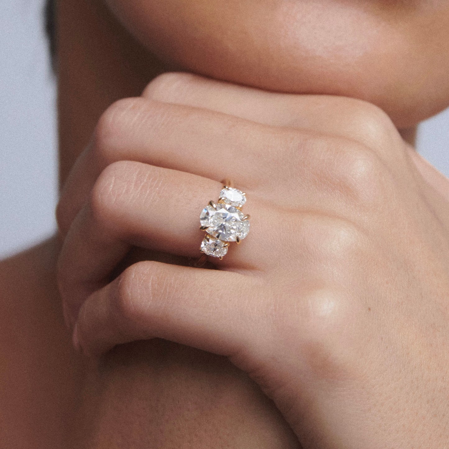 Close-up of a hand wearing a diamond ring with a blurred background