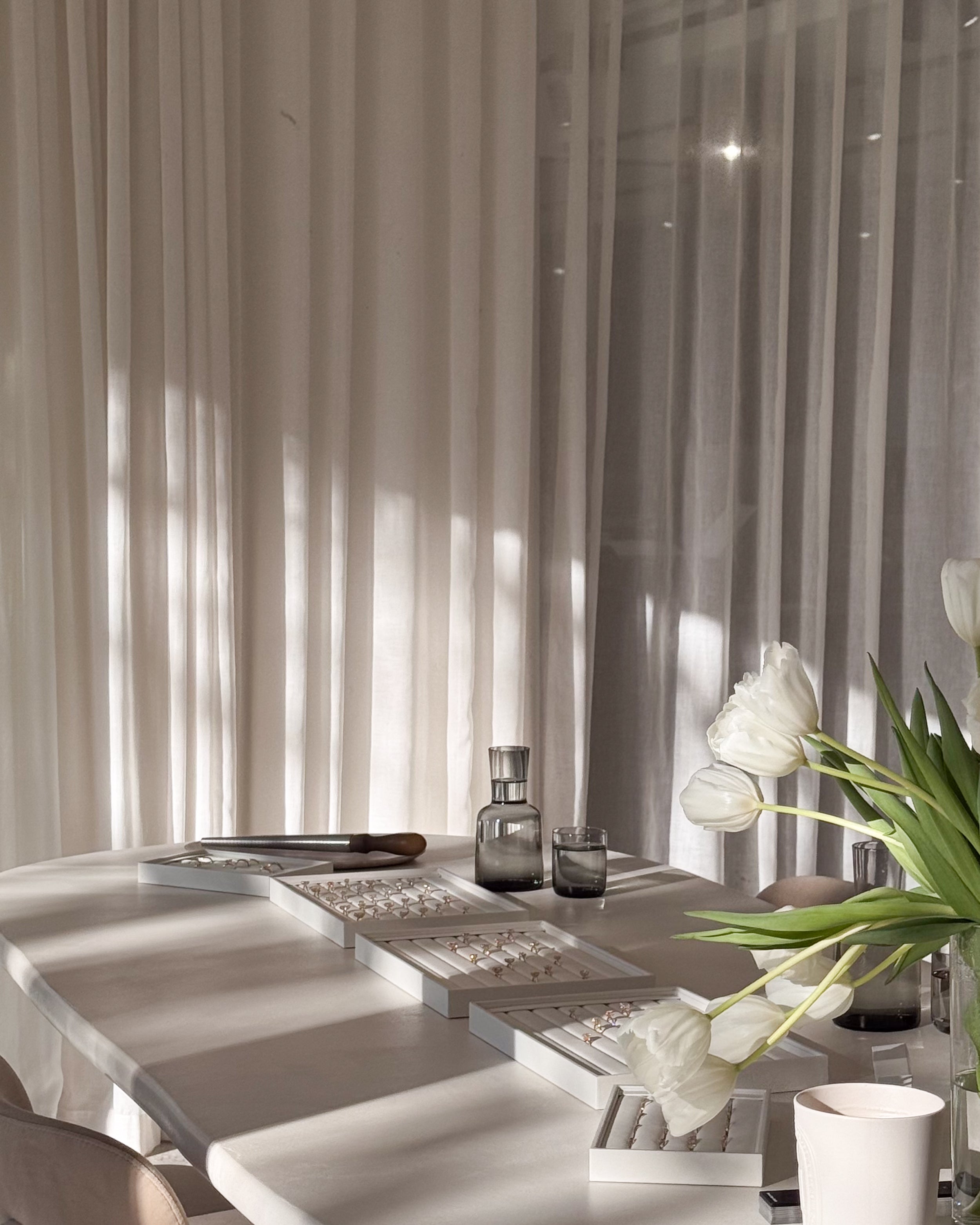 Modern interior with a table, flowers, and decorative items against a textured wall.