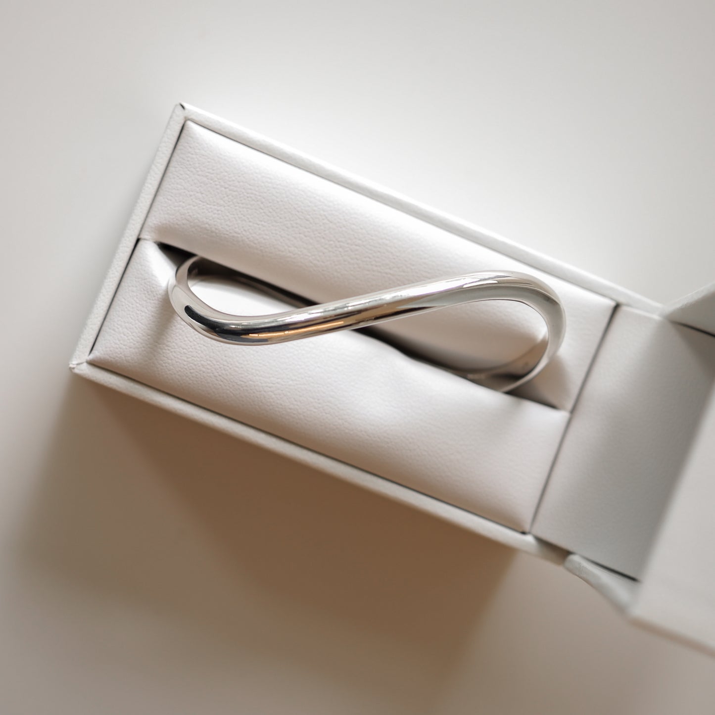 Elegant silver infinity bracelet in a white jewellery box, symbolising luxury and style. Perfect for gifting or personal elegance.