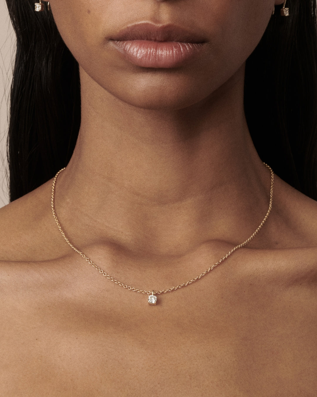 Cushion Pendant as worn by model Franciele shot on a light beige background