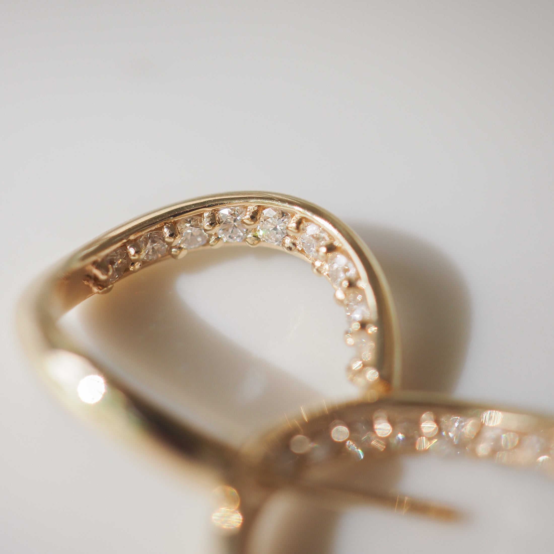 Close-up of an elegant gold ring featuring sparkling diamonds set along the band, capturing luxury jewellery design.