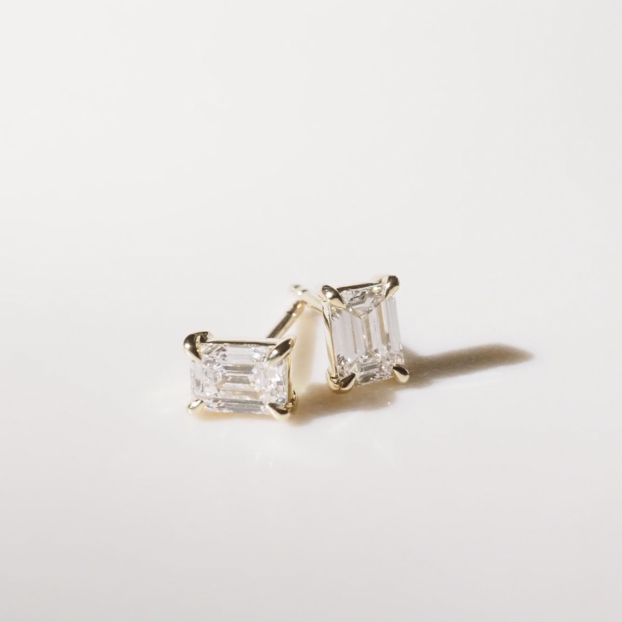 Pair of diamond stud earrings on a light gray background