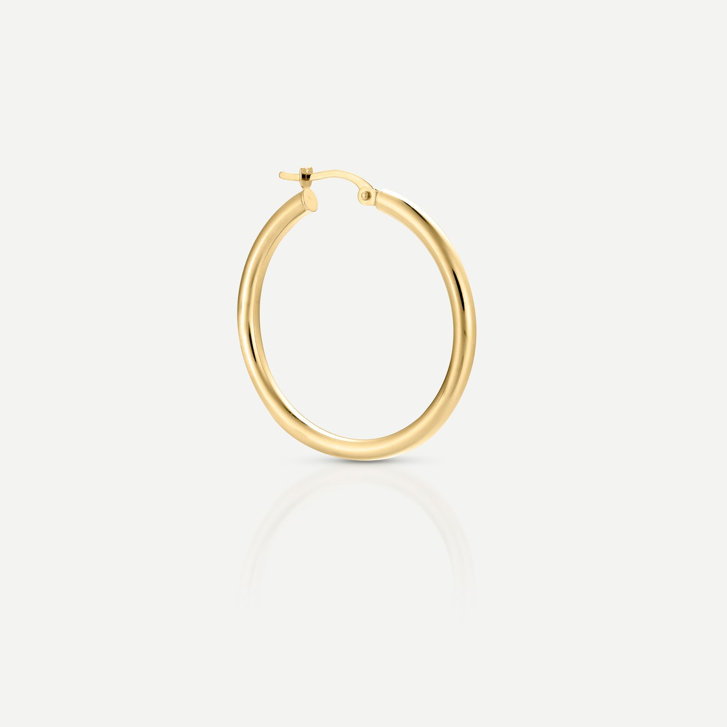 Elegant gold hoop earring against a light background, showcasing luxury jewellery design with a polished finish.