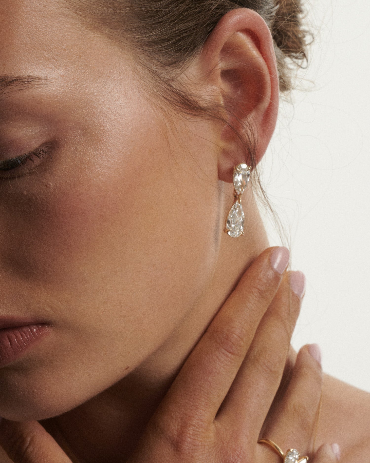 Close-up of a woman wearing a diamond earring with a soft background