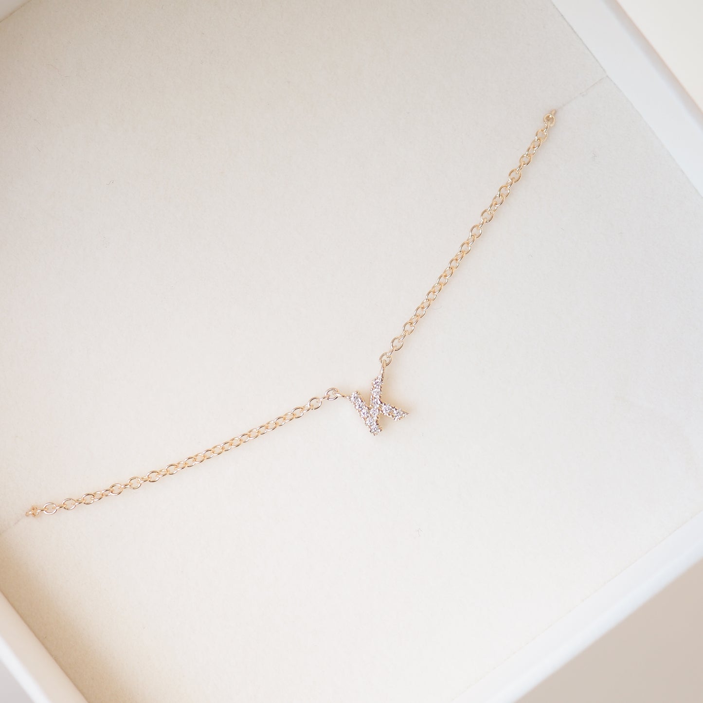 Gold diamond letter necklace on a cable chain in a box