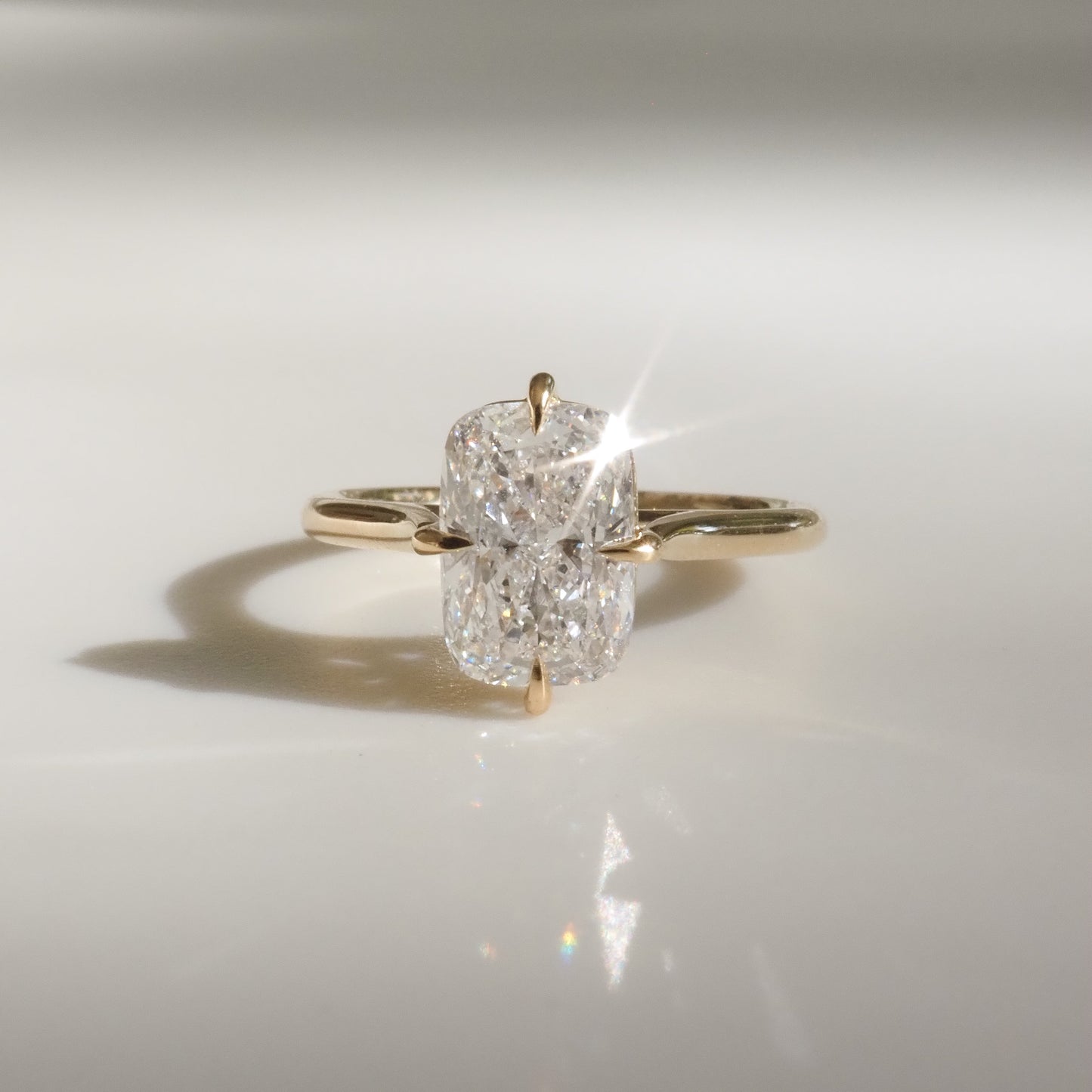 Gold ring with a radiant, rectangular diamond solitaire reflecting light. Perfect for luxury jewellery and elegant engagement pieces.