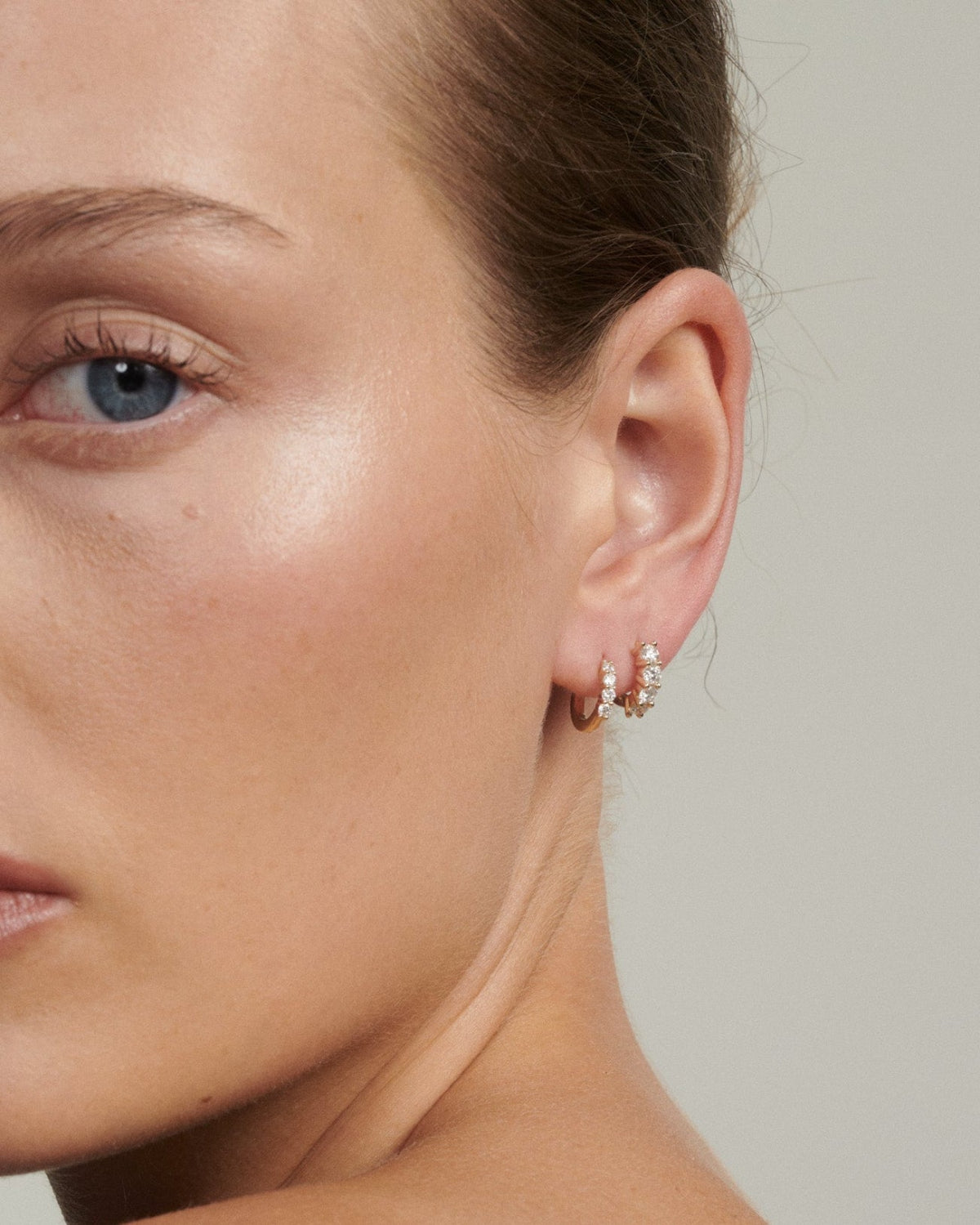 Close-up of a woman wearing earrings with a neutral background