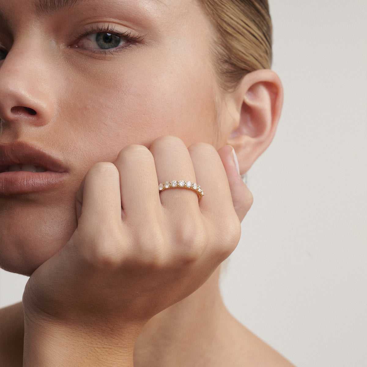 Close-up of a woman's hand with a diamond ring on a neutral background

[text overlay: Faith wears our 3mm Arraya]
