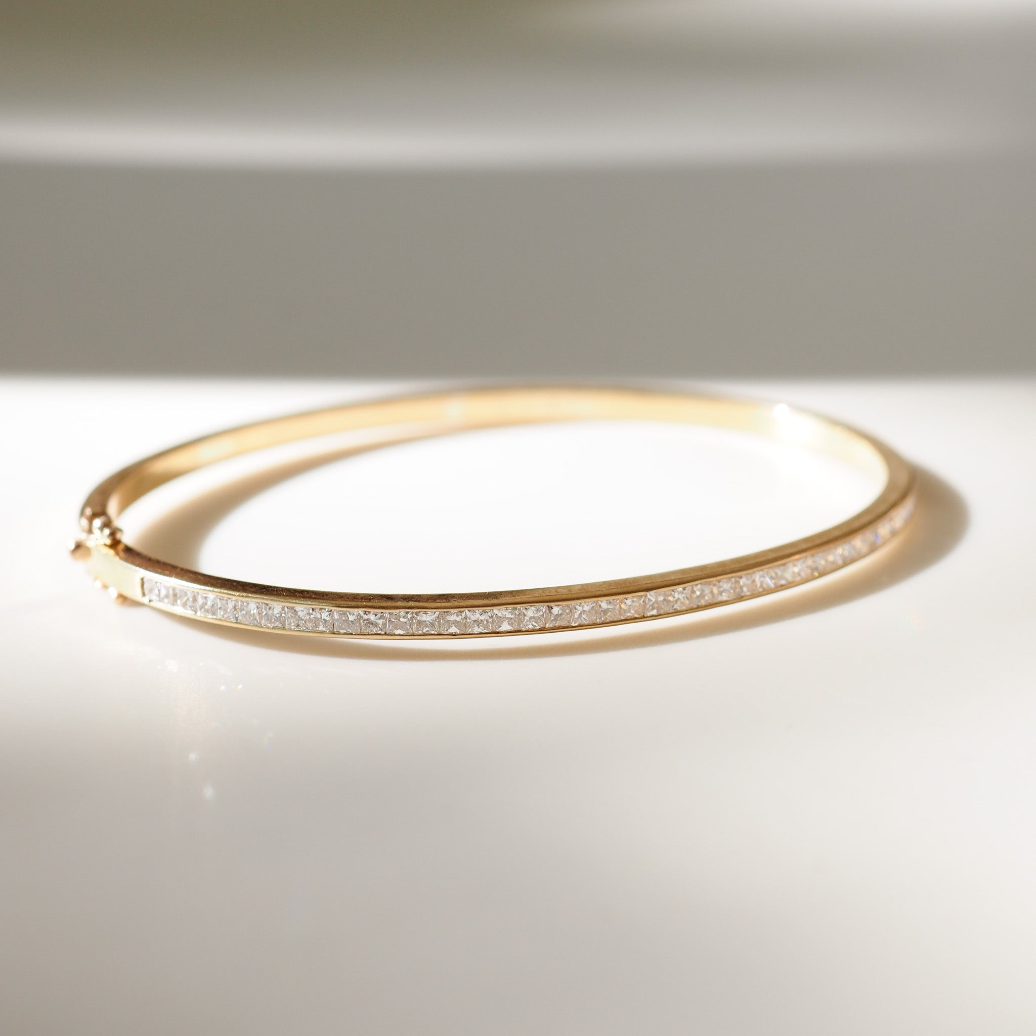 Gold bracelet with small diamonds on a light background