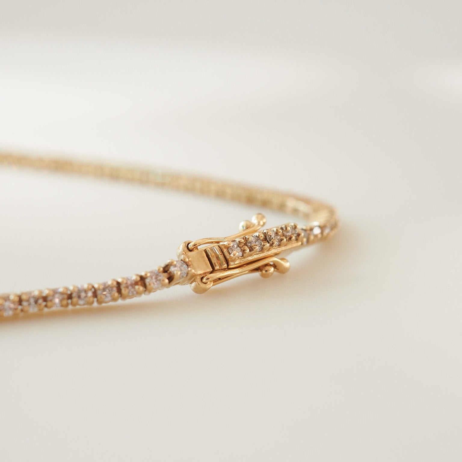 Gold bracelet with diamond accents on a light background