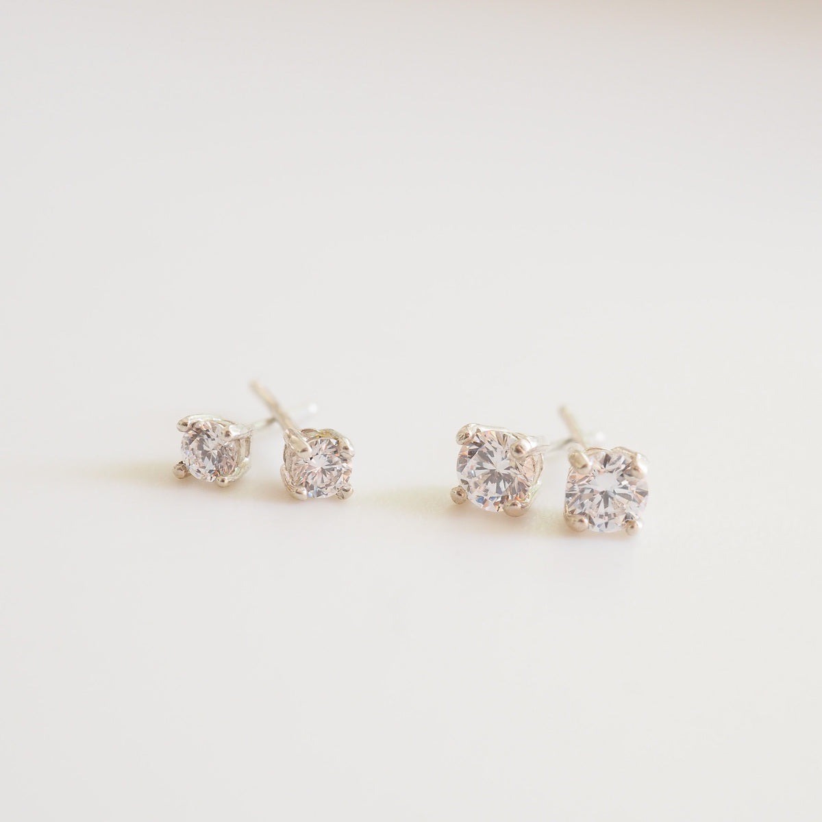 Pair of diamond stud earrings on a light background