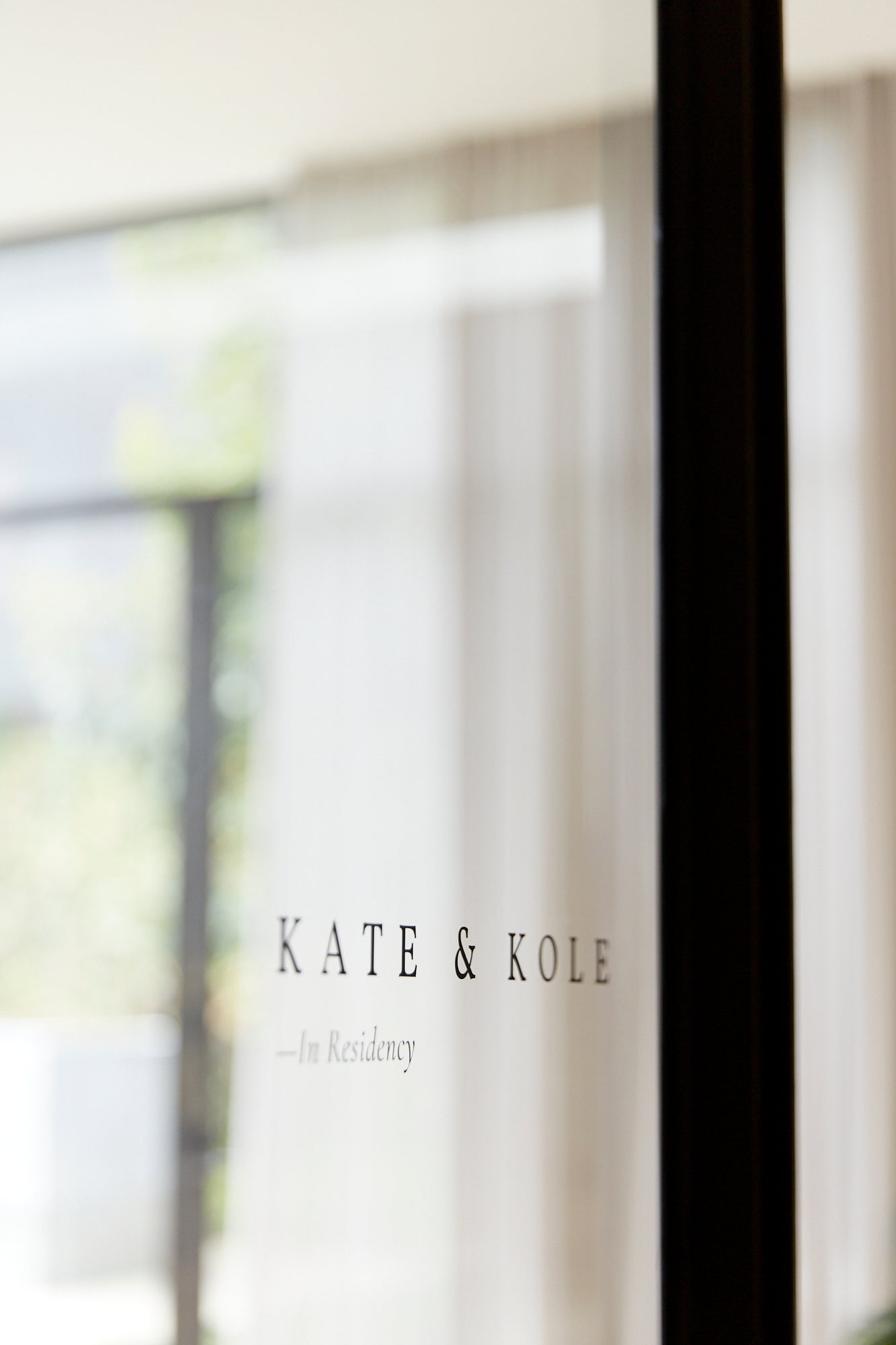 Glass door with "Kate & Kole - In Residency" text; modern, luxury jewellery showroom entrance.