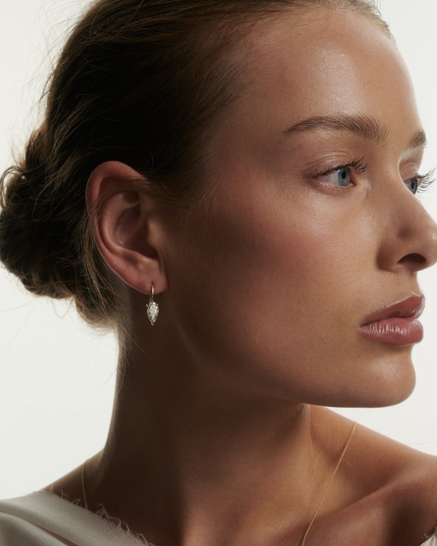 Close-up of a woman wearing an earring with a plain background