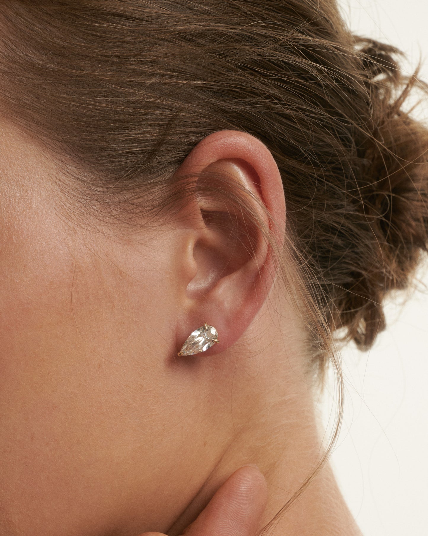 Close-up of a person wearing a silver earring with a blurred background
