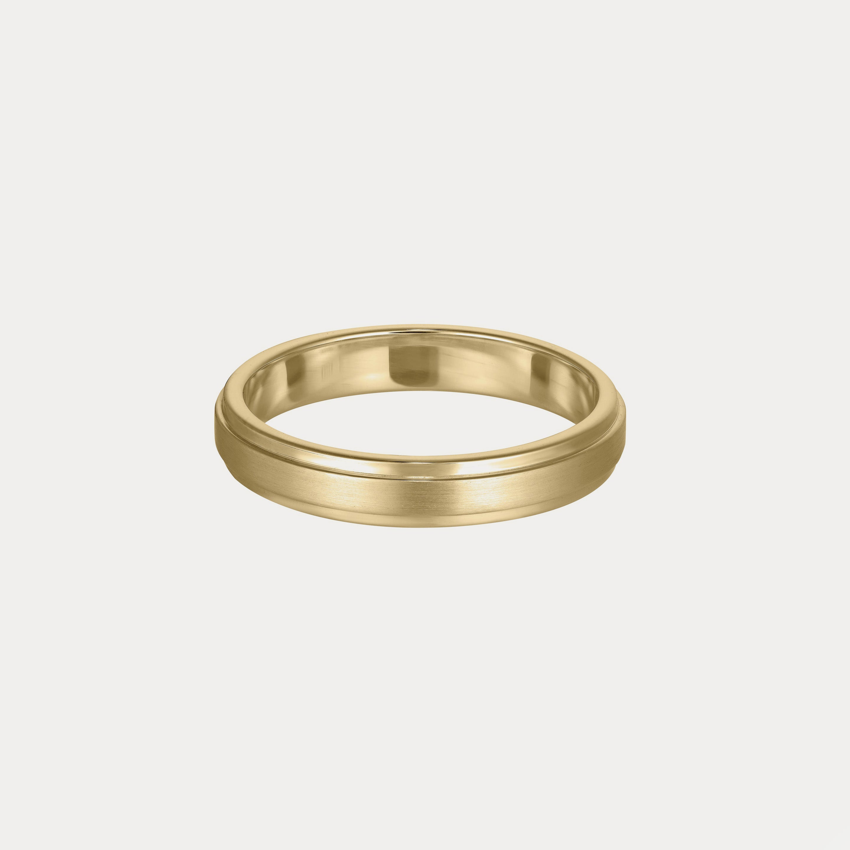Elegant gold wedding band with a brushed finish on a plain background, symbolising timeless luxury and style.