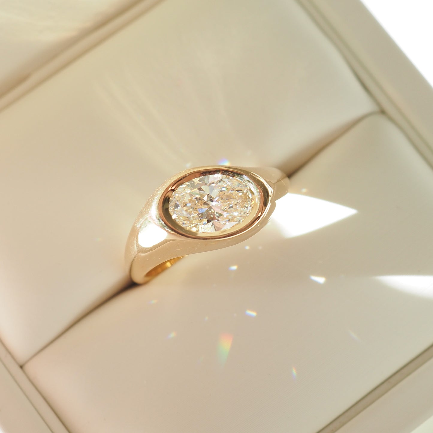 Gold ring with a diamond on a beige background