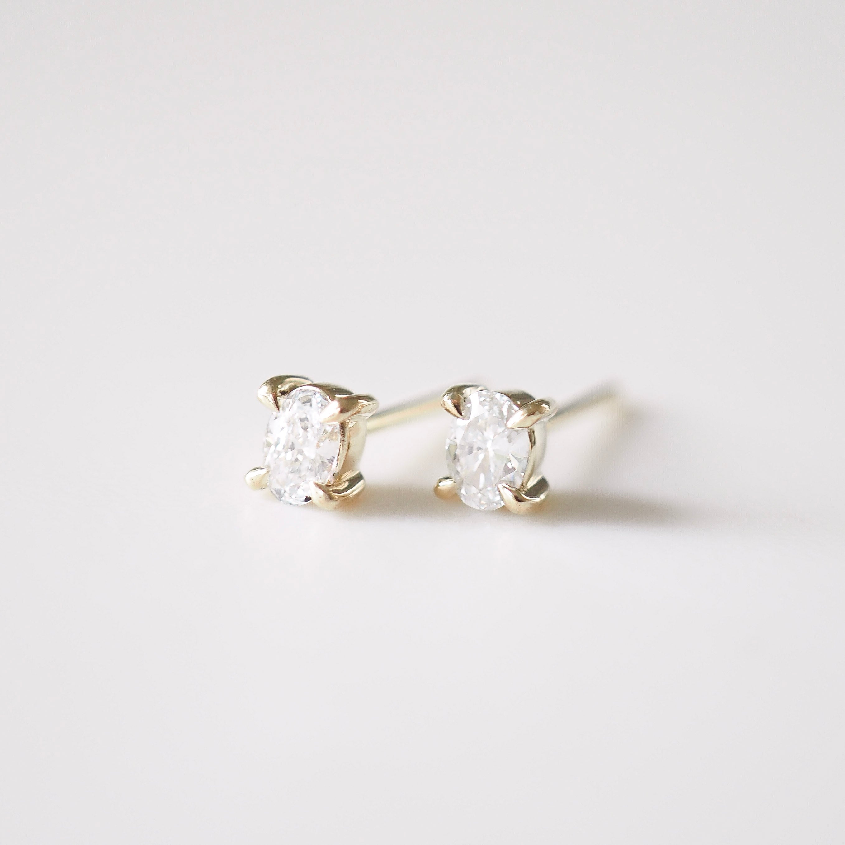 Pair of diamond stud earrings on a light gray background