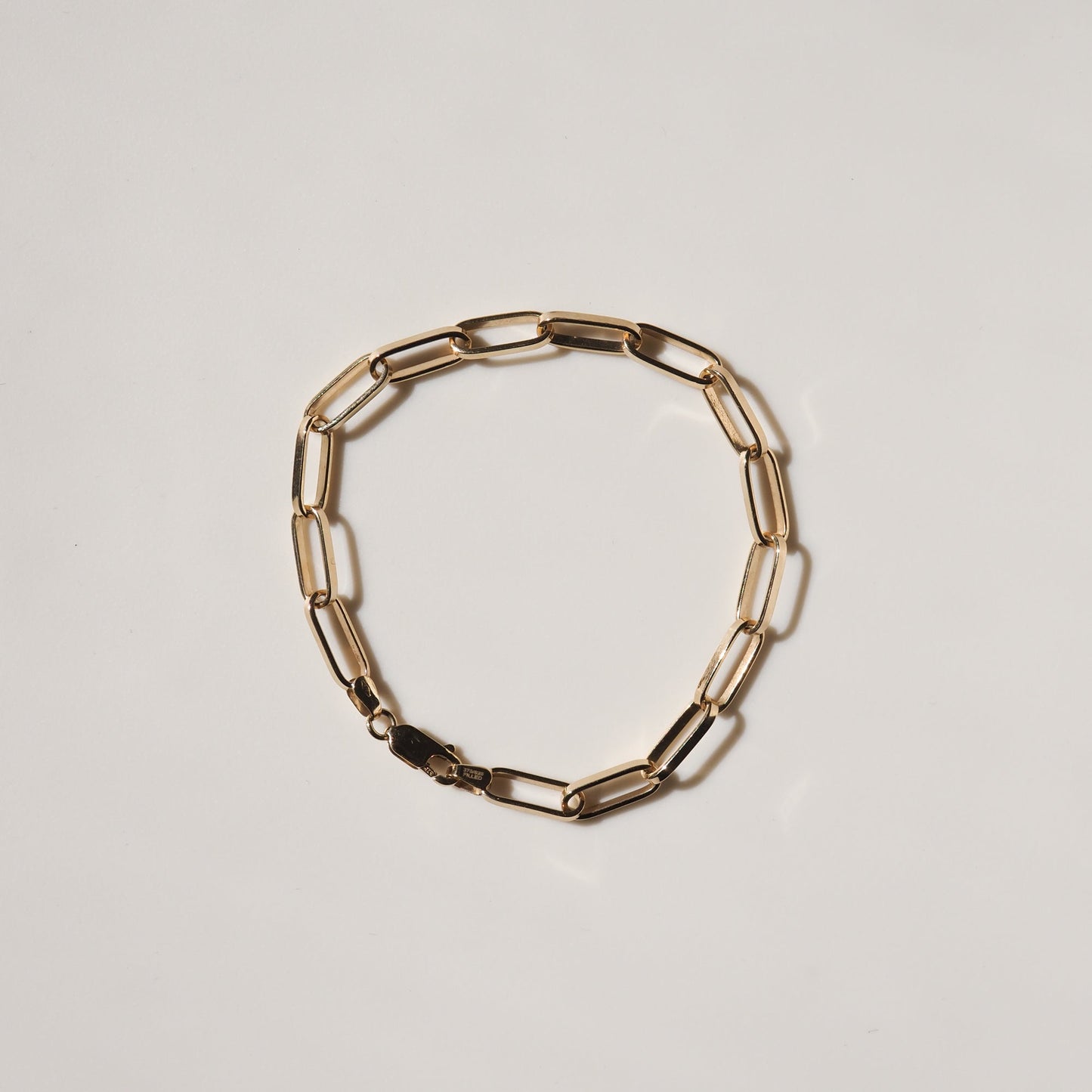 9ct gold paperclip link bracelet on a light background