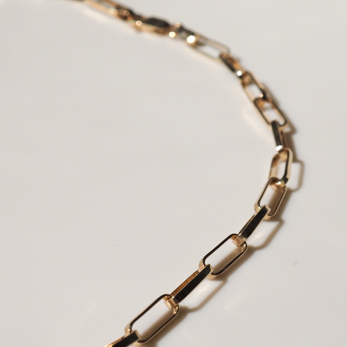 Elegant gold chain necklace with rectangular links, showcased on a plain background. Ideal for luxury jewellery enthusiasts.
