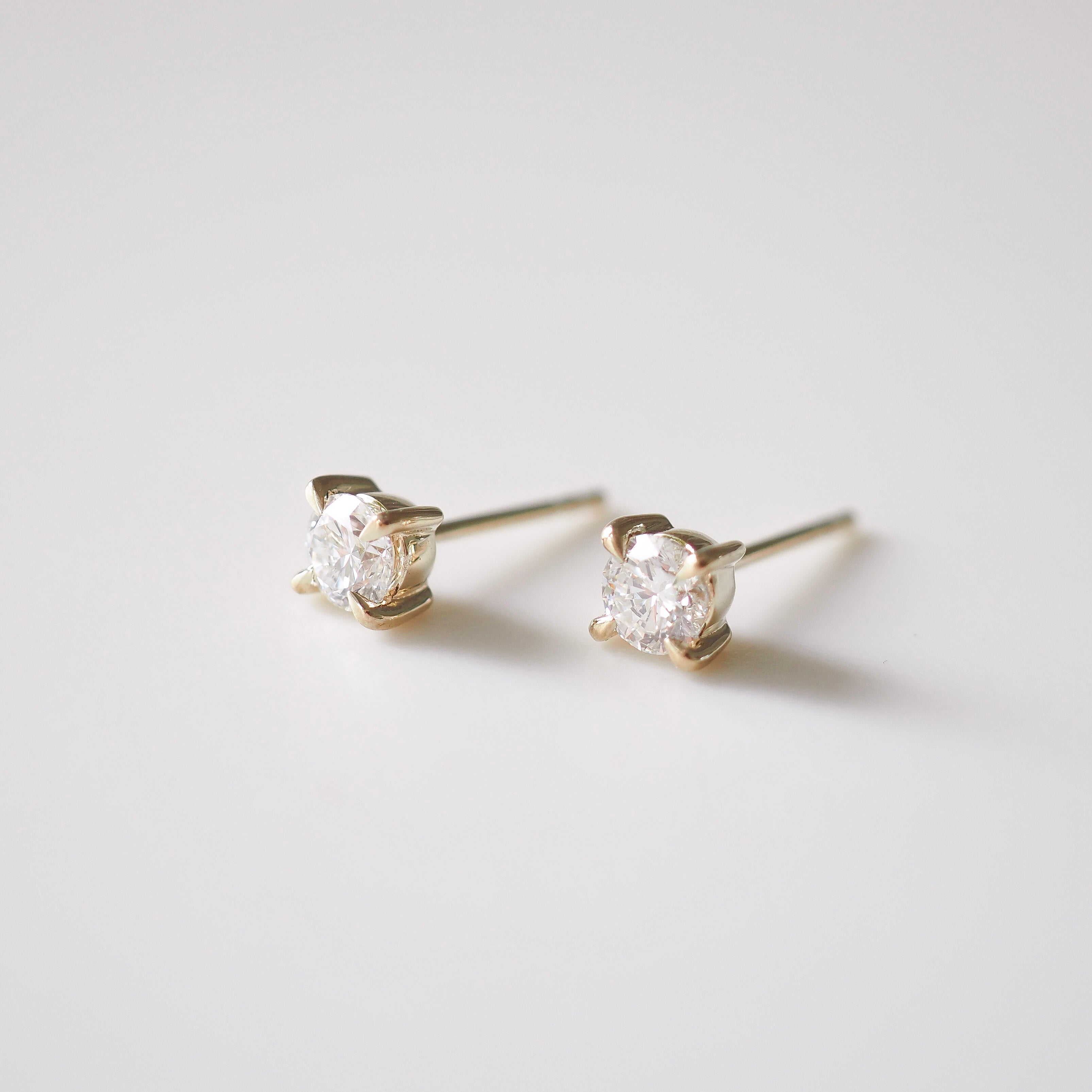 Pair of diamond stud earrings on a light gray background