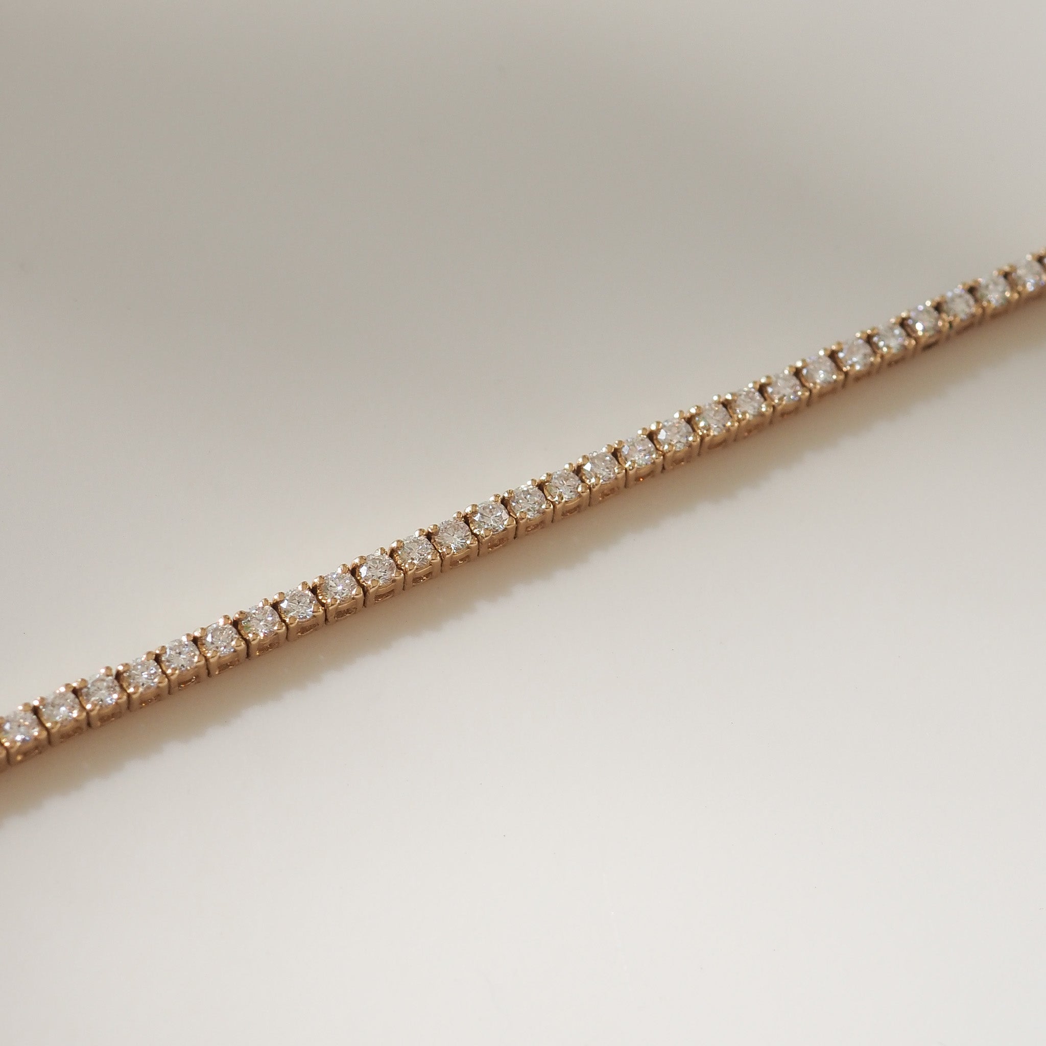 Yellow gold bracelet with diamonds on a light beige background