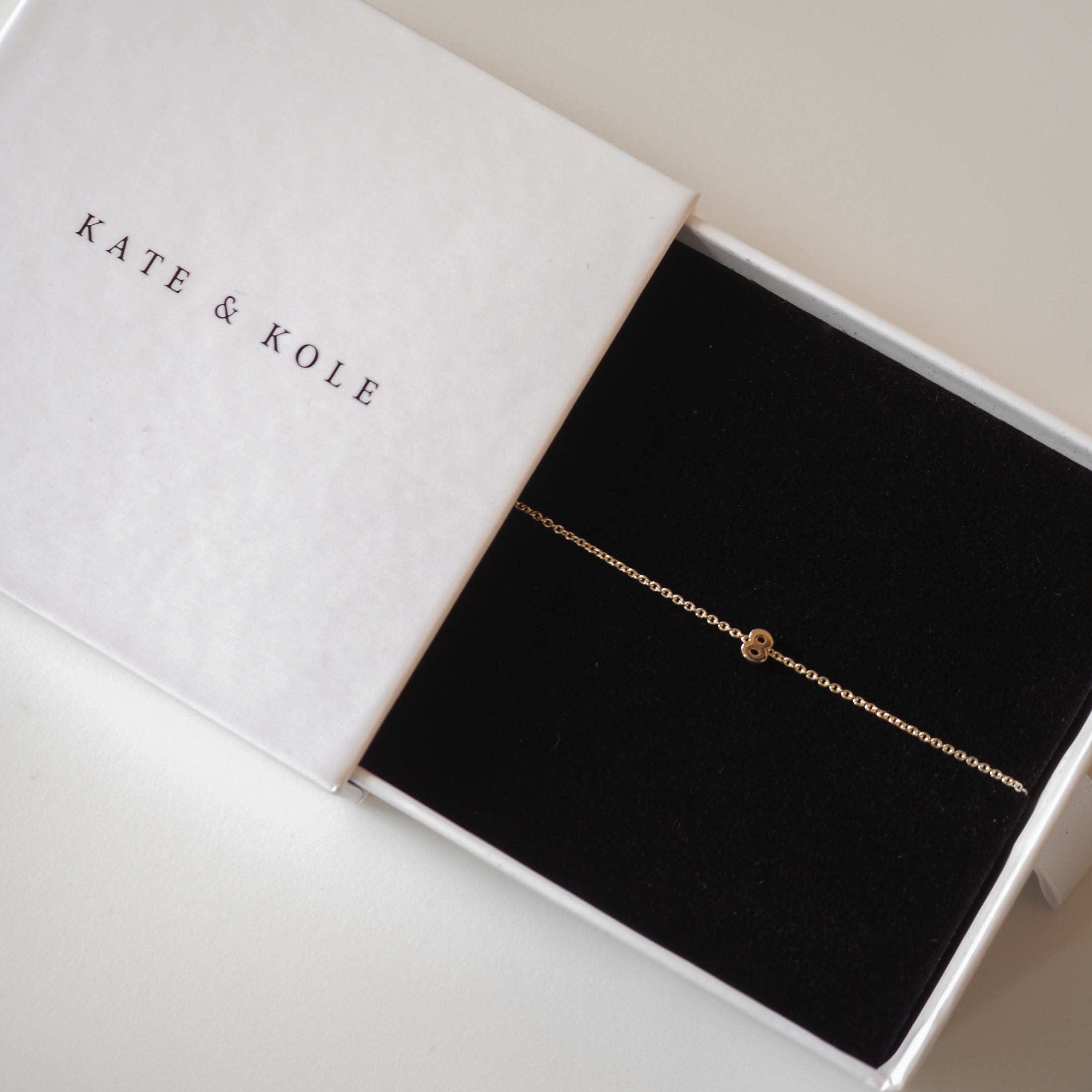Elegant gold chain bracelet with a single diamond in a Kate & Kole jewellery box. High-end, luxury accessory for women.