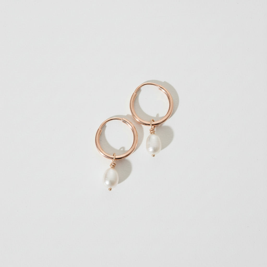 Rose gold earrings with circular design on a white background