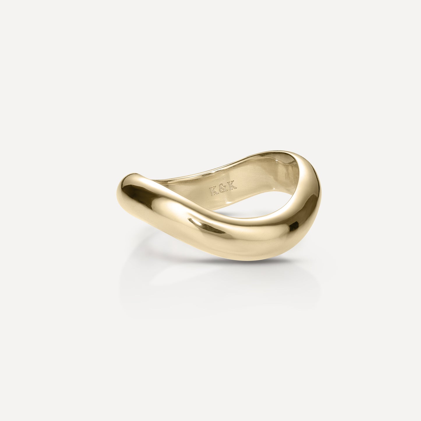 Sculptural gold ring with a smooth, flowing design on a light background. Luxurious, minimalist jewellery piece.