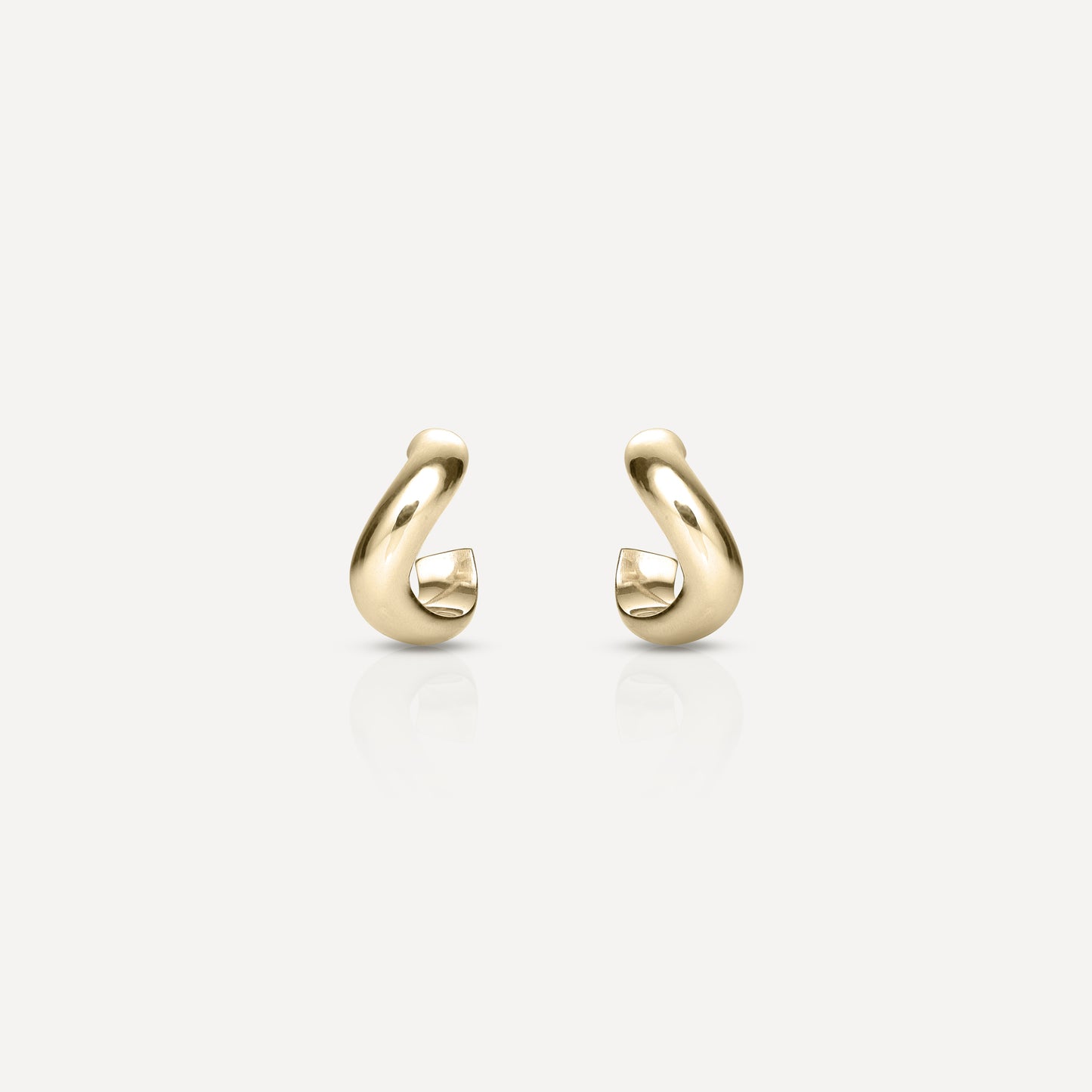 Gold hoop earrings with a modern, curved design on a white background. Simple luxury jewellery piece.